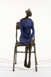 A seated figure in blue waits quietly in this contemplative paper mache sculpture by Paul Duval.