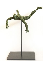 A male figure with legs spread eagle and arms reaching for the ground falls towards earth in this green patinated bronze sculpture.